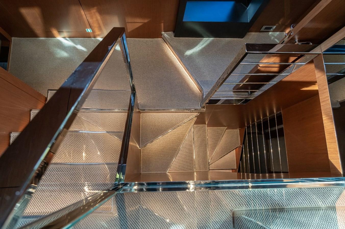 a wooden staircase with glass railings aboard BEYOND BEYOND Yacht for Sale