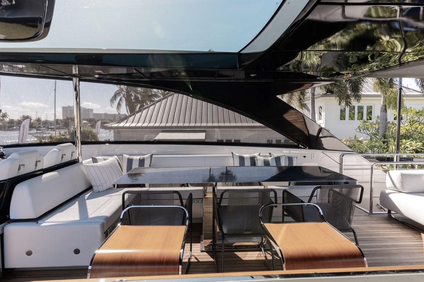 a deck with a table and chairs aboard BEYOND BEYOND Yacht for Sale