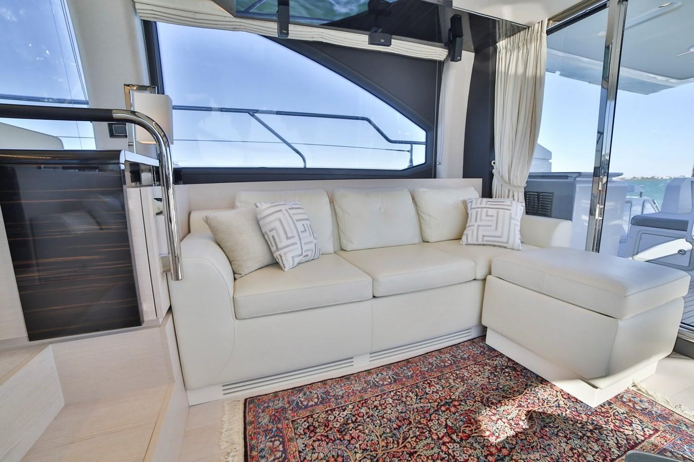 a living room with a couch and a window aboard SIRONA JOANNAH Yacht for Sale