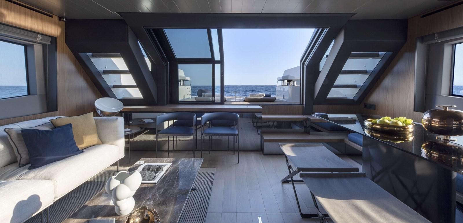 a room with a couch and a table with a view of the ocean aboard ELLEMAR Yacht for Sale