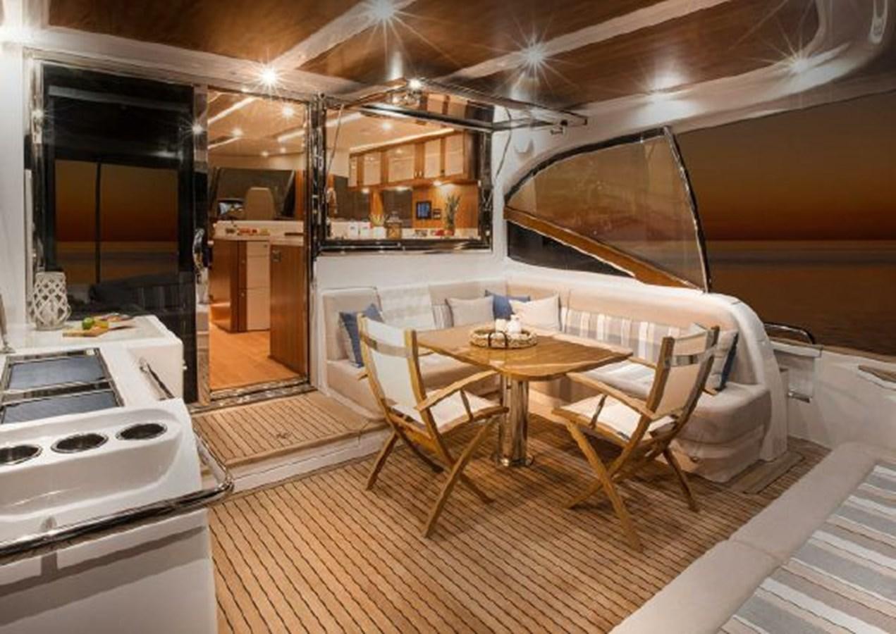 a modern kitchen with a dining table aboard 2023 RIVIERA 66 BELIZE DAYBRIDGE Yacht for Sale