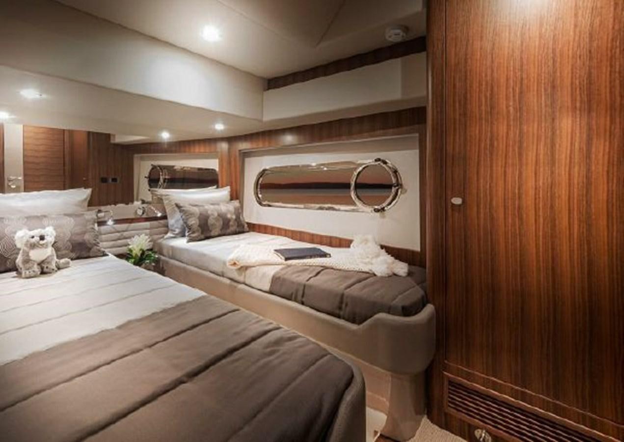 a room with a bed and a mirror aboard 2023 RIVIERA 66 BELIZE DAYBRIDGE Yacht for Sale