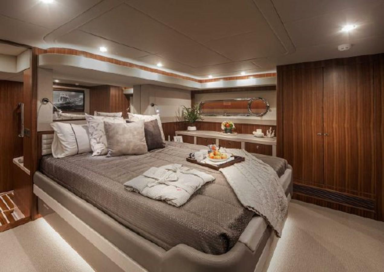 a bed with a white sheet and pillows aboard 2023 RIVIERA 66 BELIZE DAYBRIDGE Yacht for Sale