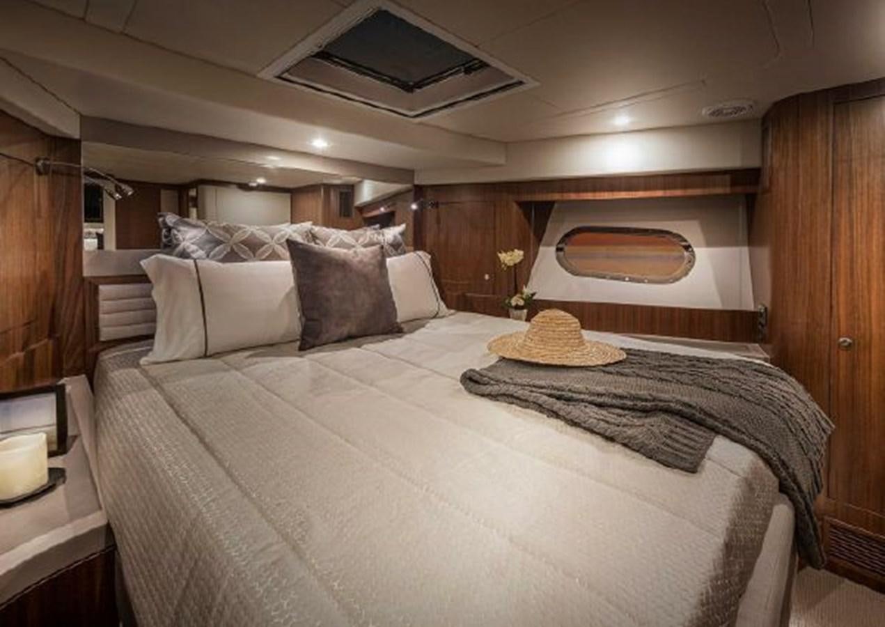 a bed with a pillow and pillows aboard 2023 RIVIERA 66 BELIZE DAYBRIDGE Yacht for Sale