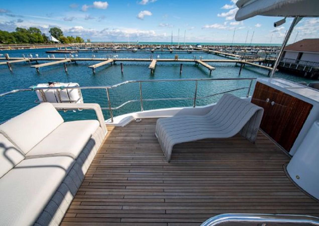 a deck with a pool and a deck with chairs and a building in the background aboard 2016 AZIMUT MAGELLANO 66 Yacht for Sale