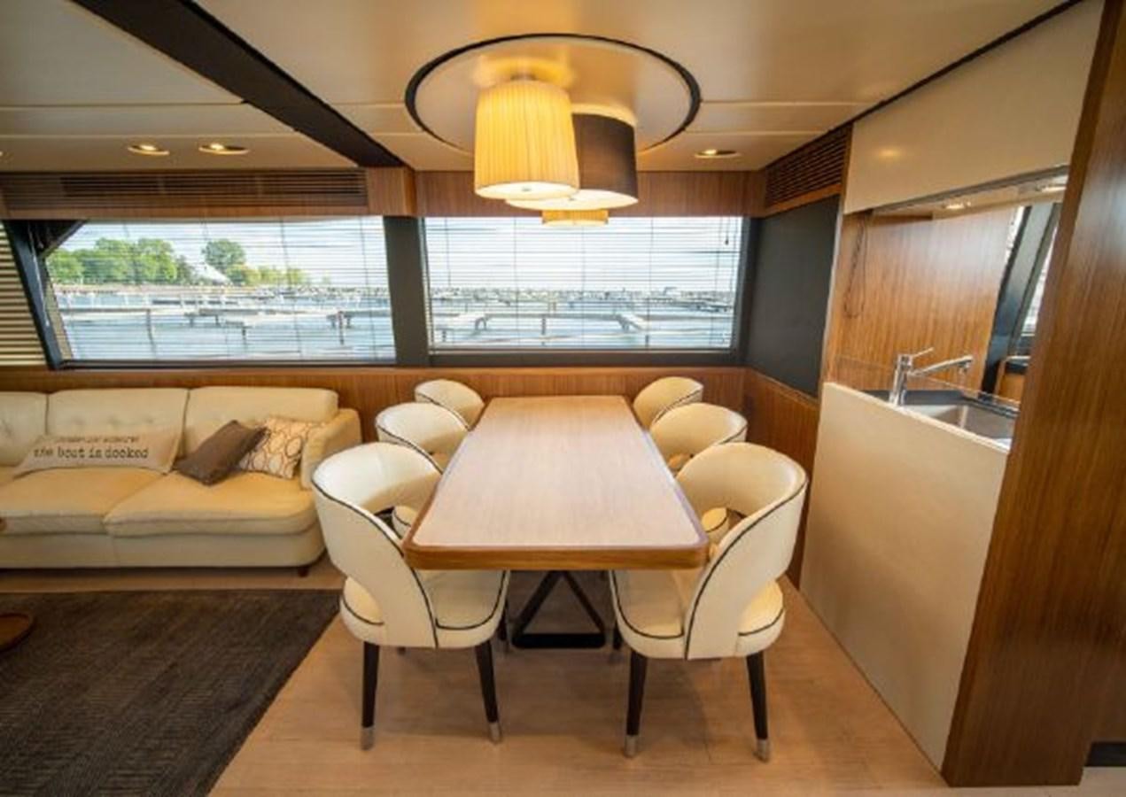 a living room with a table and chairs aboard 2016 AZIMUT MAGELLANO 66 Yacht for Sale