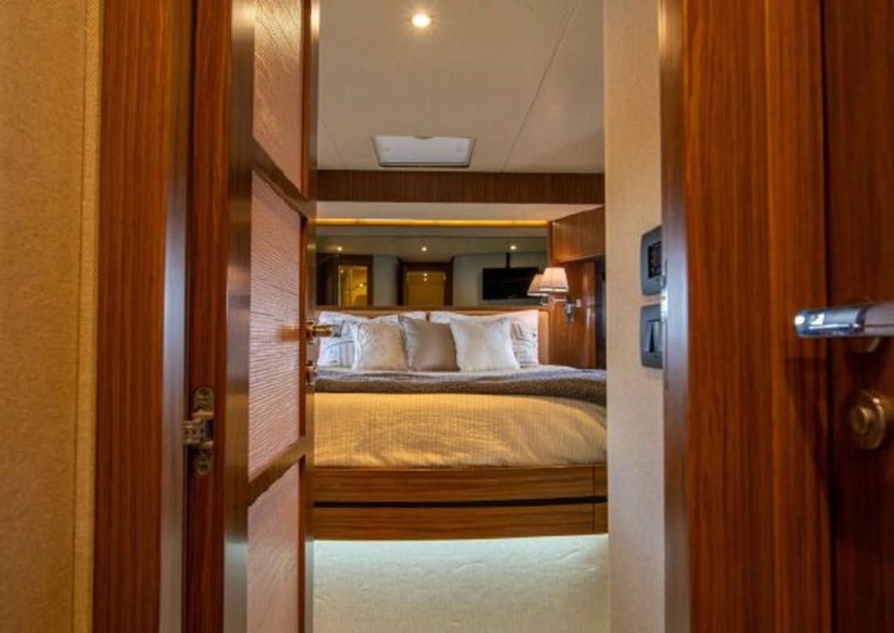 a bedroom with a bed and a wood door aboard 2016 AZIMUT MAGELLANO 66 Yacht for Sale