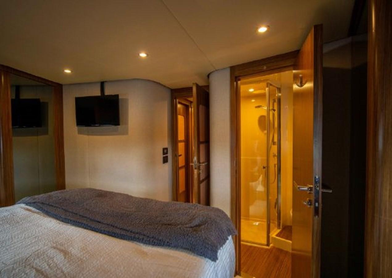 a bedroom with a bed and a television on the wall aboard 2016 AZIMUT MAGELLANO 66 Yacht for Sale
