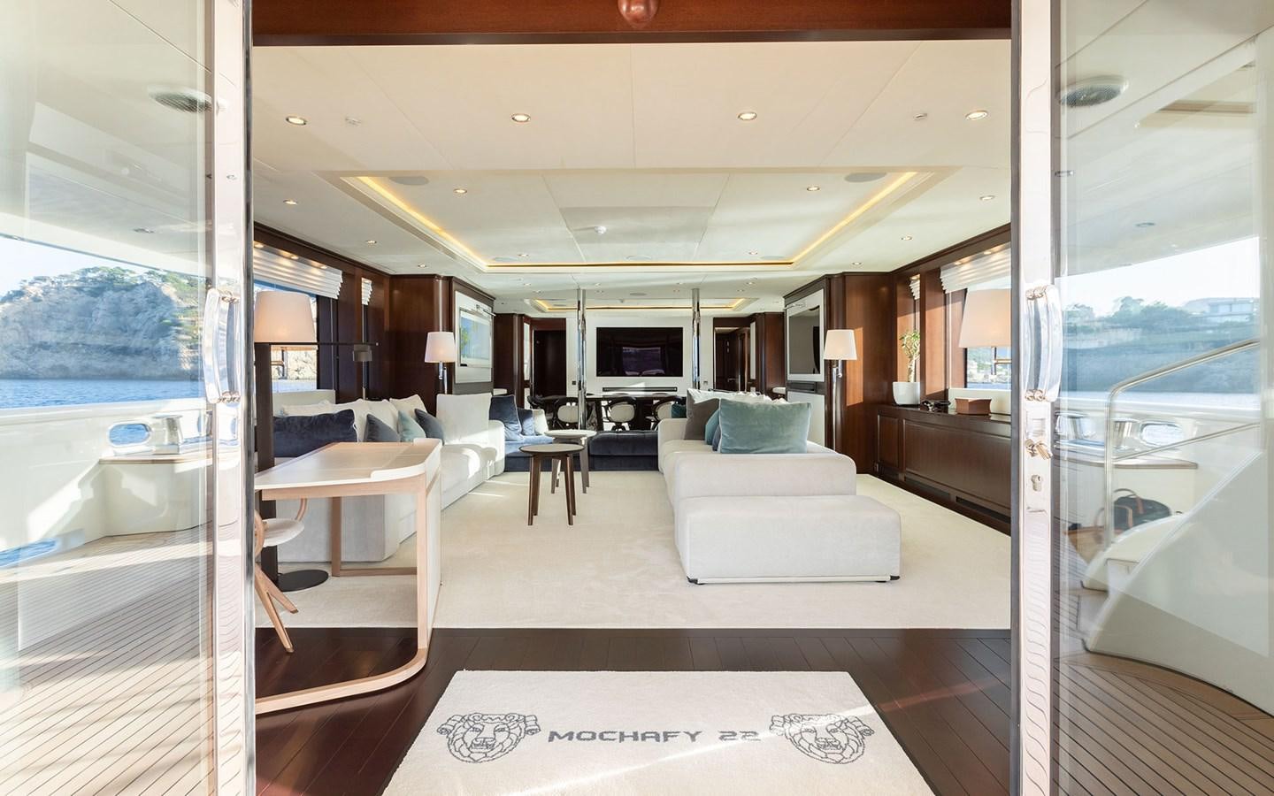 a room with a couch and a table and a window aboard MAXIMILIAN MMIV Yacht for Charter