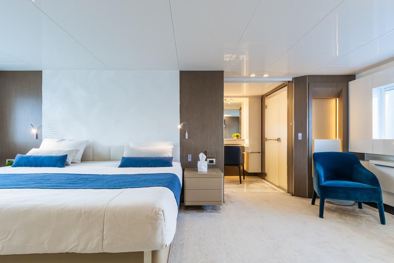 a bedroom with a blue chair aboard MILU' Yacht for Sale