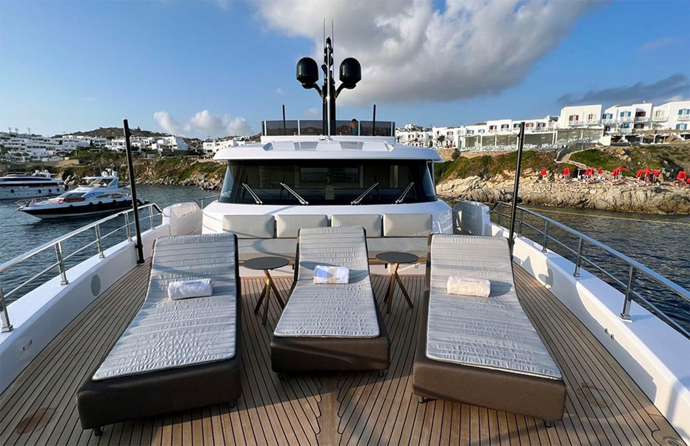 a deck with chairs and a boat on it aboard CHECKMATE Yacht for Sale