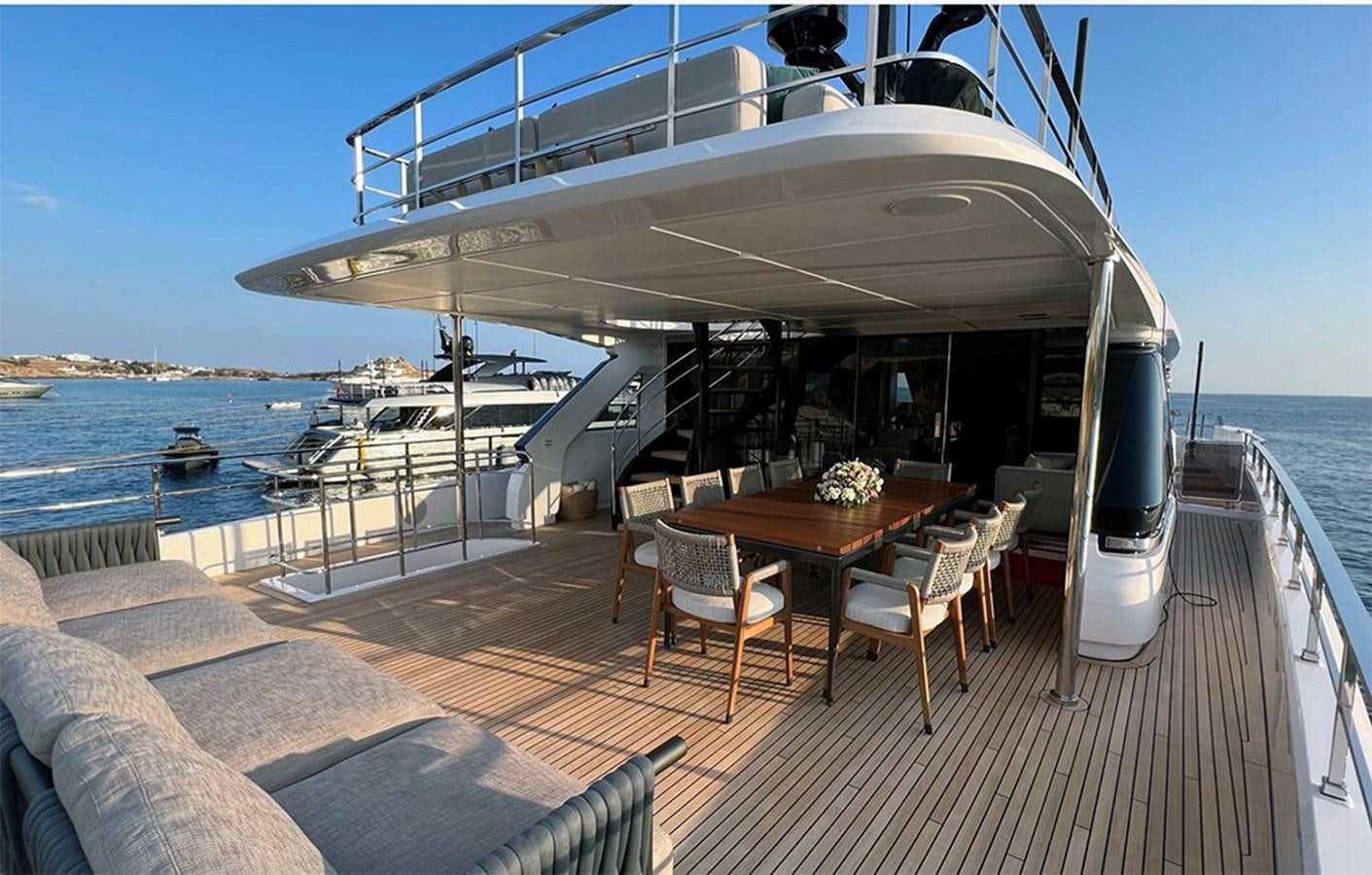 a deck with a table and chairs on it aboard CHECKMATE Yacht for Sale