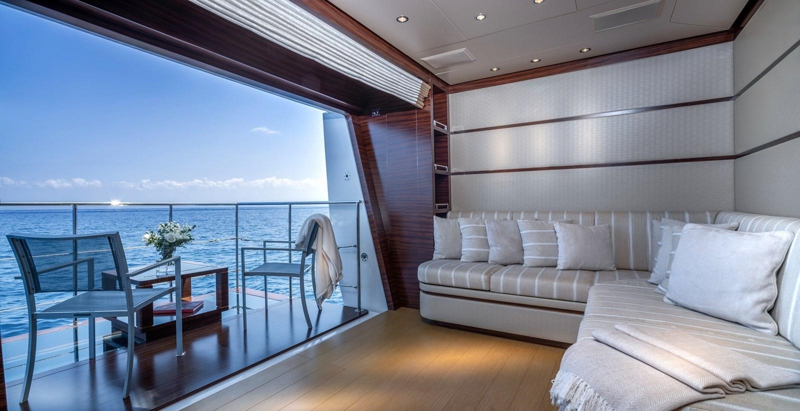 a room with a couch and a table and a view of the ocean aboard ATLAS Yacht for Sale