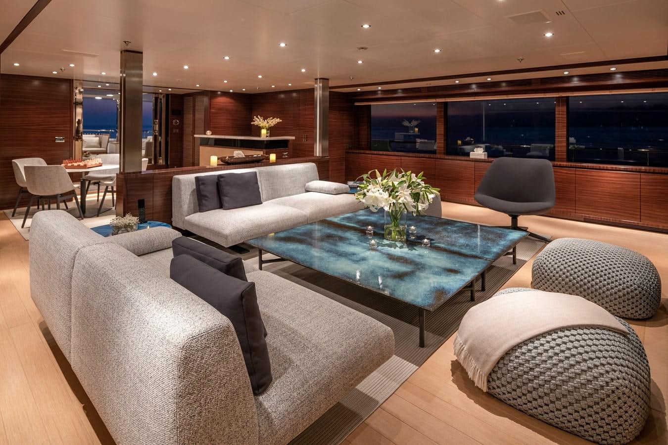 a living room with a large blue table and chairs aboard ATLAS Yacht for Sale