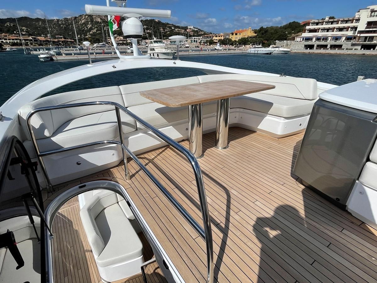 a deck with a table and chairs on it aboard LESTO Yacht for Sale