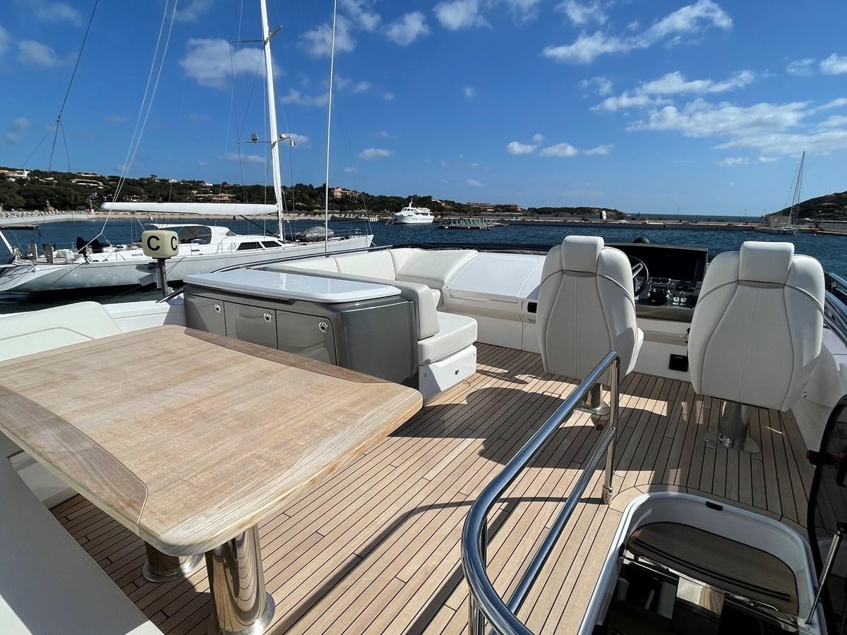 a deck with a table and chairs on it aboard LESTO Yacht for Sale