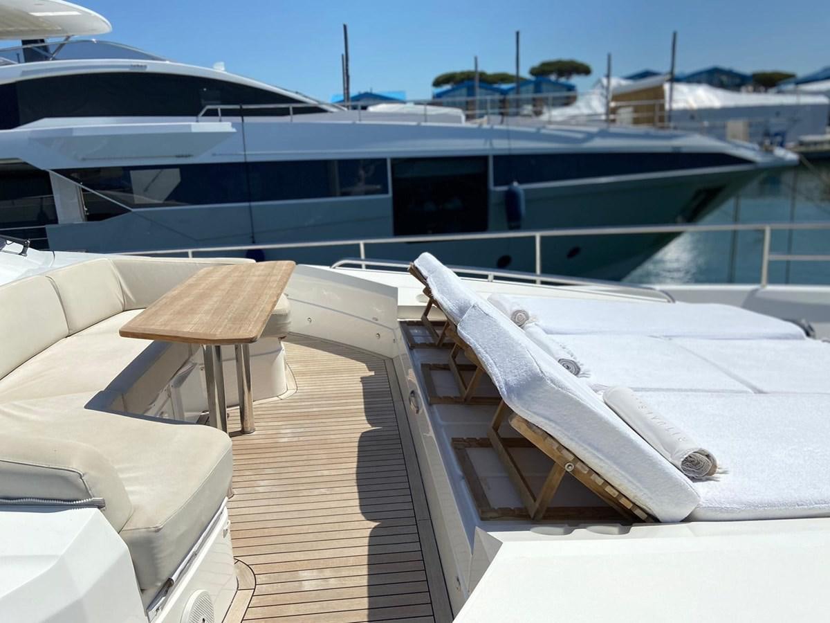 a deck with chairs and a large ship in the background aboard EXPERIENCE Yacht for Sale