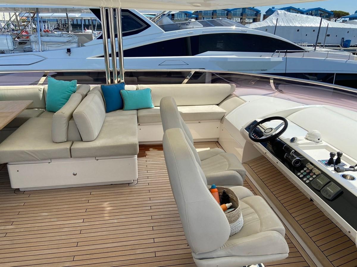 a deck with a large yacht and lounge chairs on it aboard EXPERIENCE Yacht for Sale