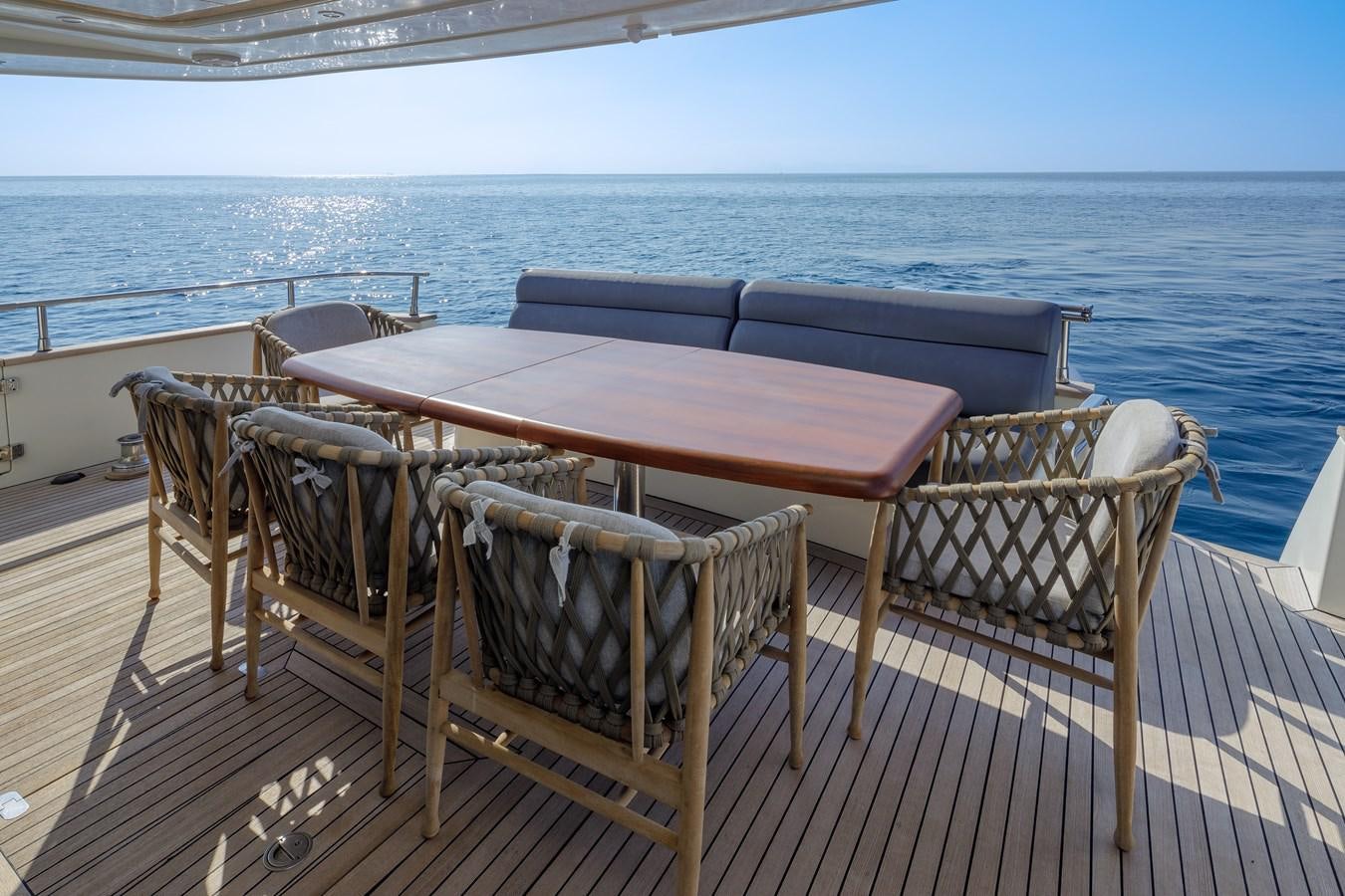a table and chairs on a deck overlooking the ocean aboard SALTY Yacht for Sale