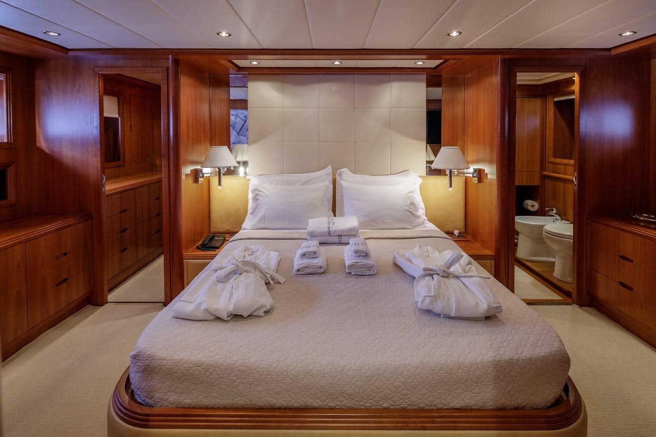 a bed with a white sheet on it aboard SALTY Yacht for Sale