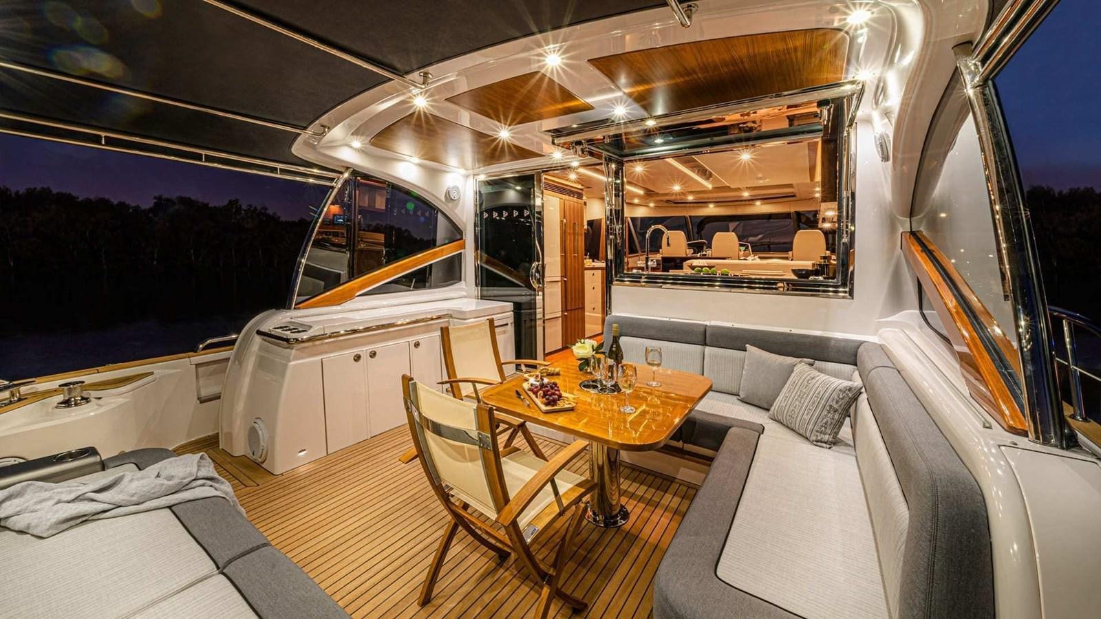 inside of a vehicle with a table and chairs and a bed aboard BELIZE 66 SEDAN Yacht for Sale