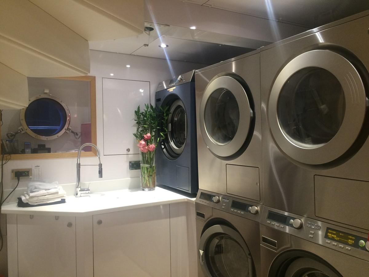 a kitchen with white cabinets and a large fan aboard THE BIG BLUE Yacht for Sale