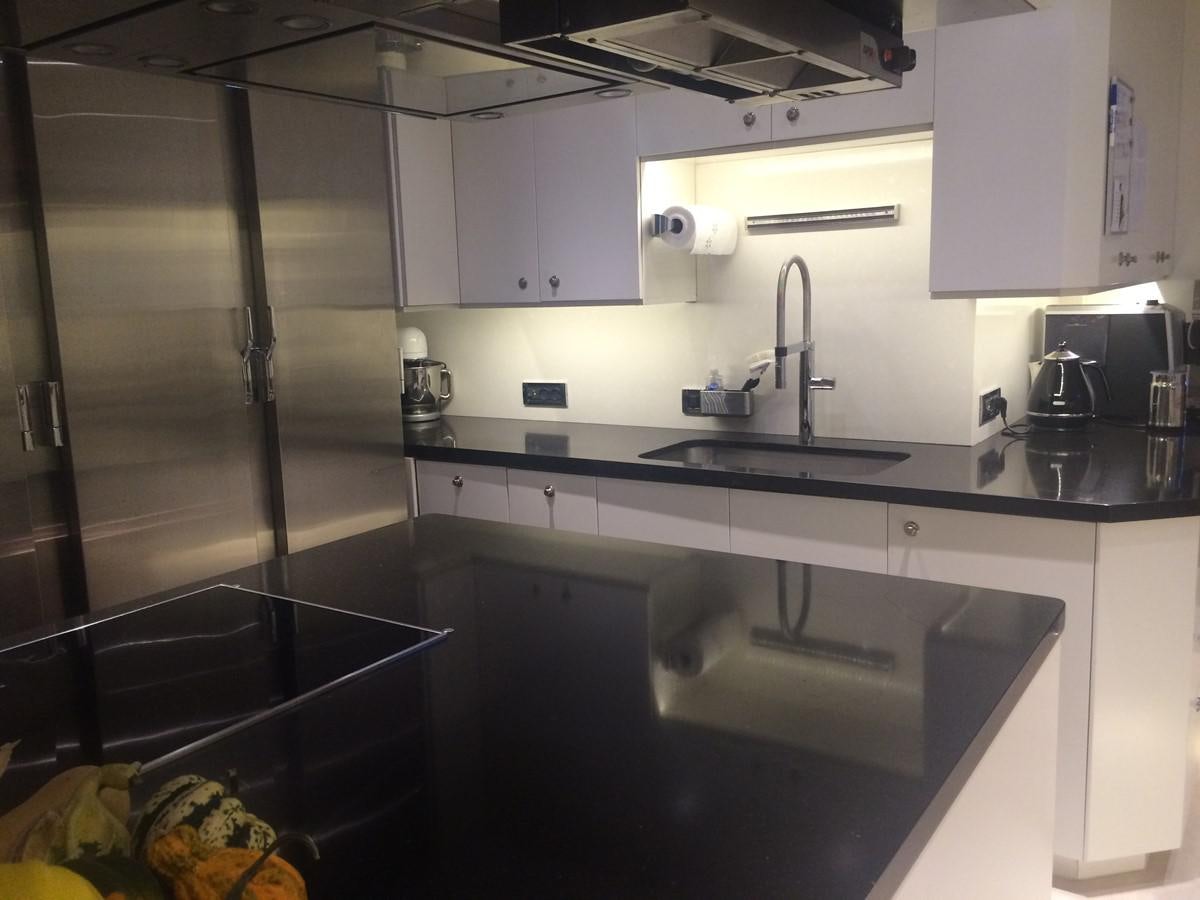 a kitchen with a sink and a refrigerator aboard THE BIG BLUE Yacht for Sale