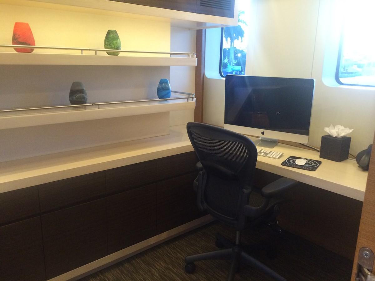 a desk with a computer and a shelf with a bookcase aboard THE BIG BLUE Yacht for Sale