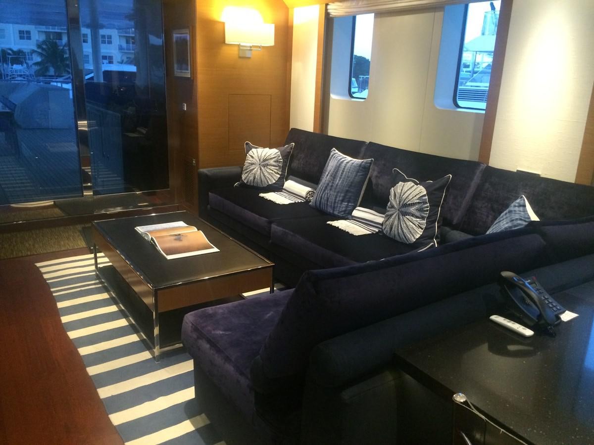 a living room with a black couch and a coffee table aboard THE BIG BLUE Yacht for Sale