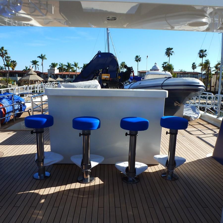 a table with blue stools and a black bird on it aboard THE BIG BLUE Yacht for Sale