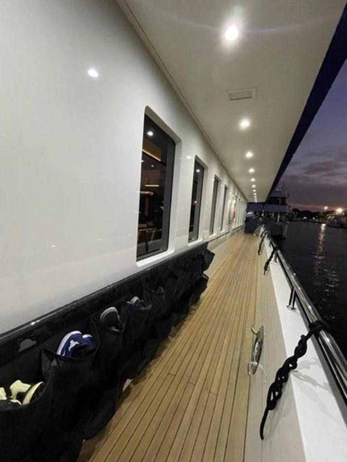 a long hallway with a door and a window aboard THE BIG BLUE Yacht for Sale