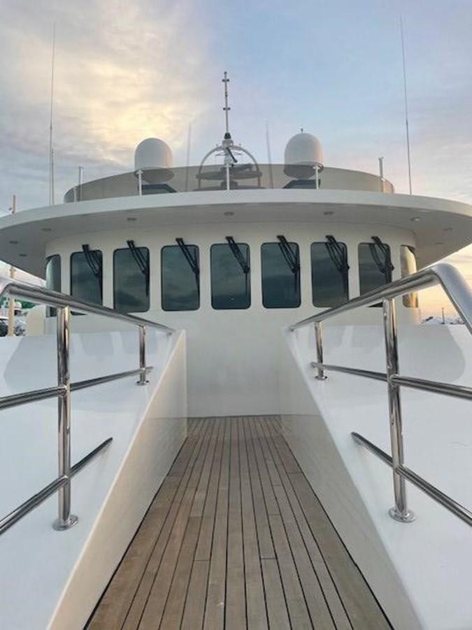 a white boat with a white awning and a white building with windows aboard THE BIG BLUE Yacht for Sale