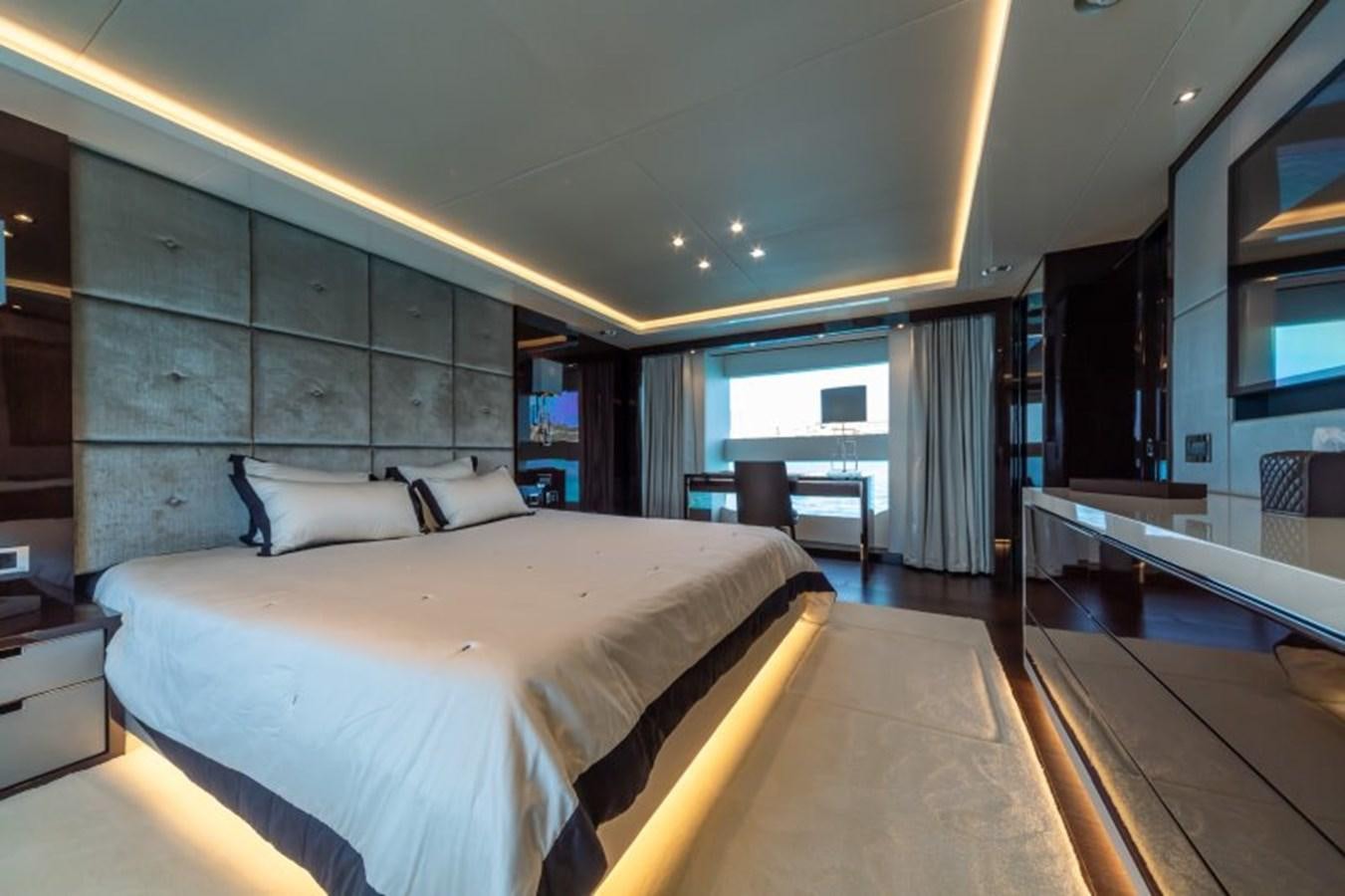 a bedroom with a bed and a desk aboard SURVIVOR 2 Yacht for Sale