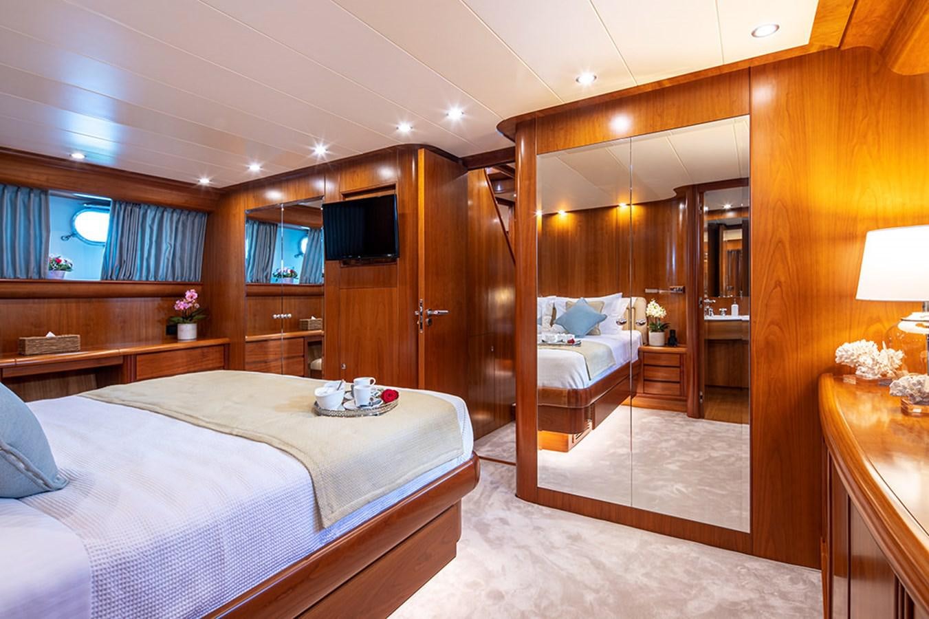 a bedroom with a bed and a mirror aboard VYNO Yacht for Sale
