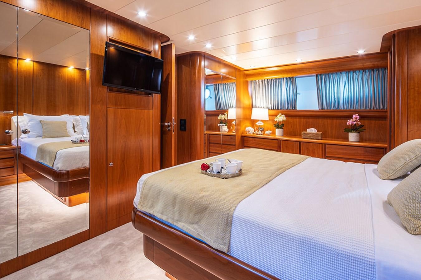 a room with a bed and a television aboard VYNO Yacht for Sale