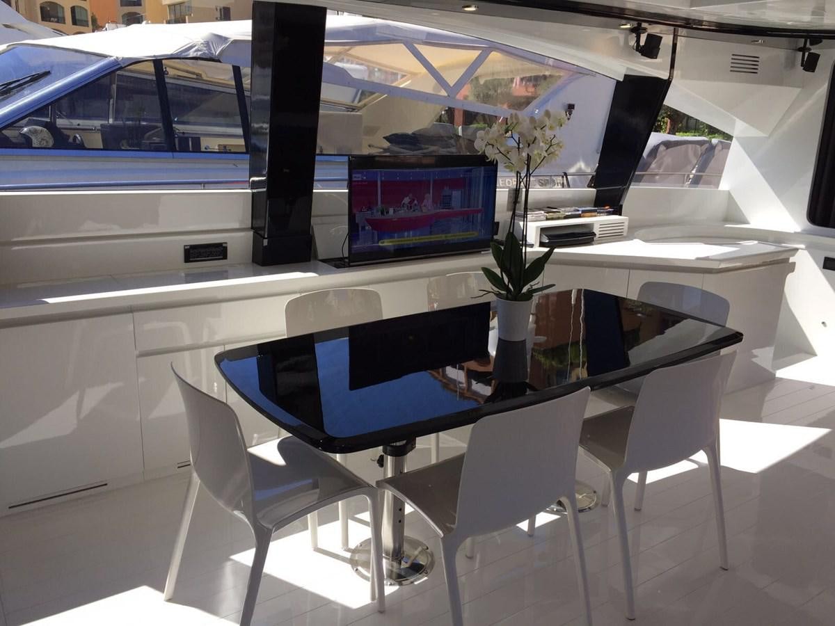 a table with chairs and a laptop aboard FORZA 8 Yacht for Sale