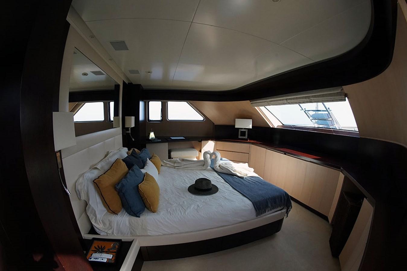 a bedroom with a bed and a window aboard AKUA Yacht for Sale