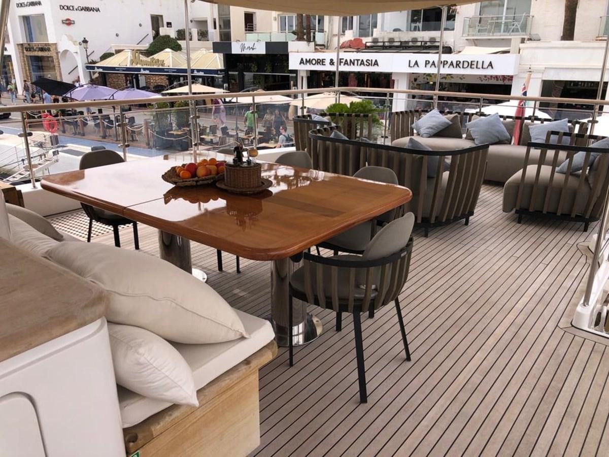 a table and chairs on a deck aboard AKUA Yacht for Sale