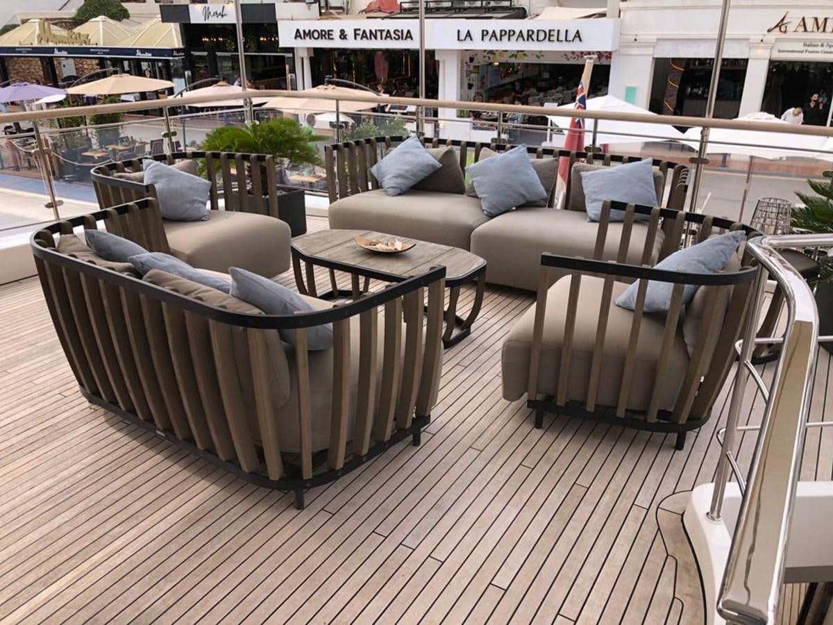a deck with couches and chairs aboard AKUA Yacht for Sale