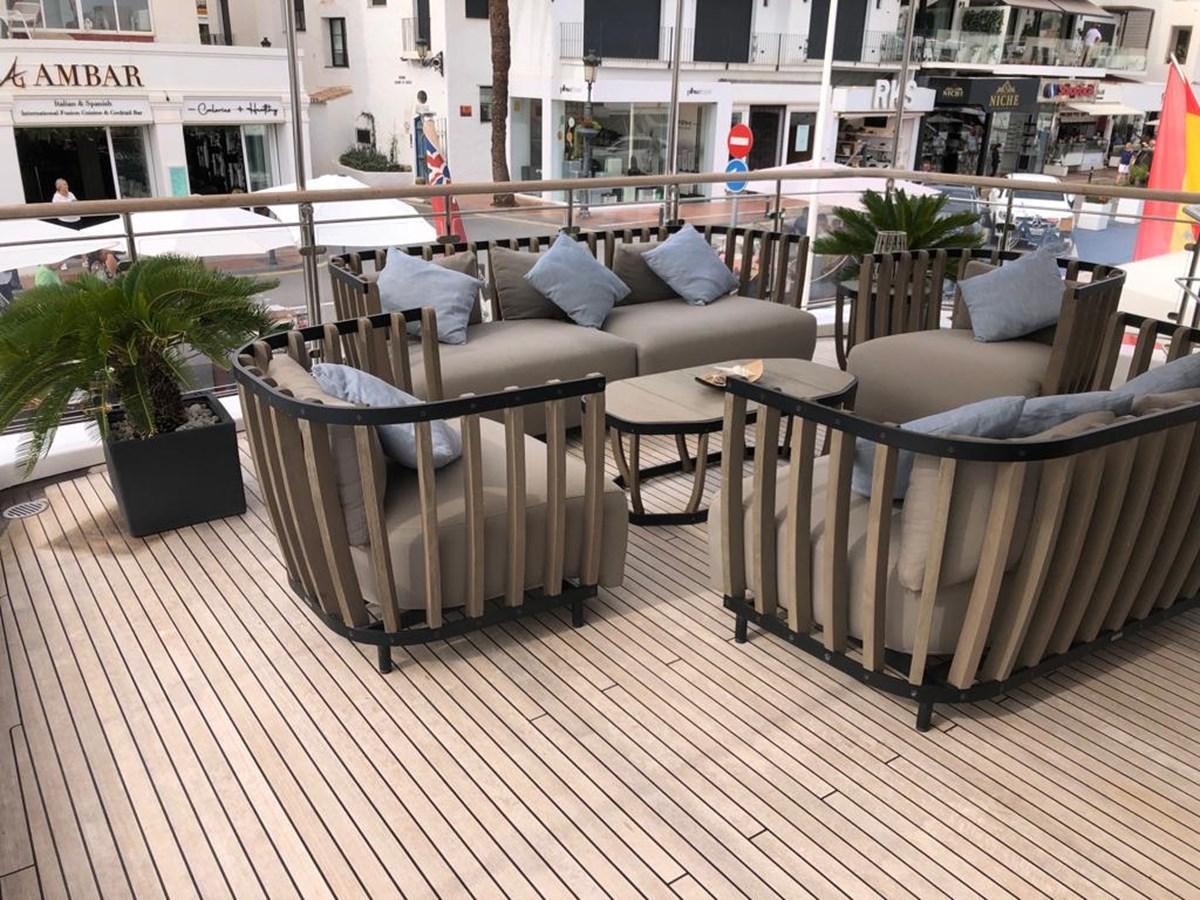 a couch and a table on a deck aboard AKUA Yacht for Sale