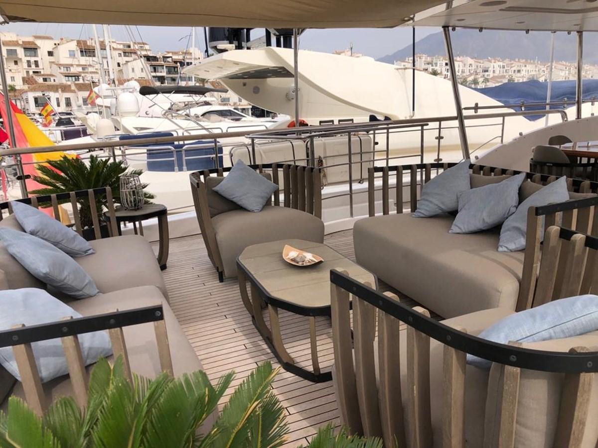 a patio with chairs and tables aboard AKUA Yacht for Sale
