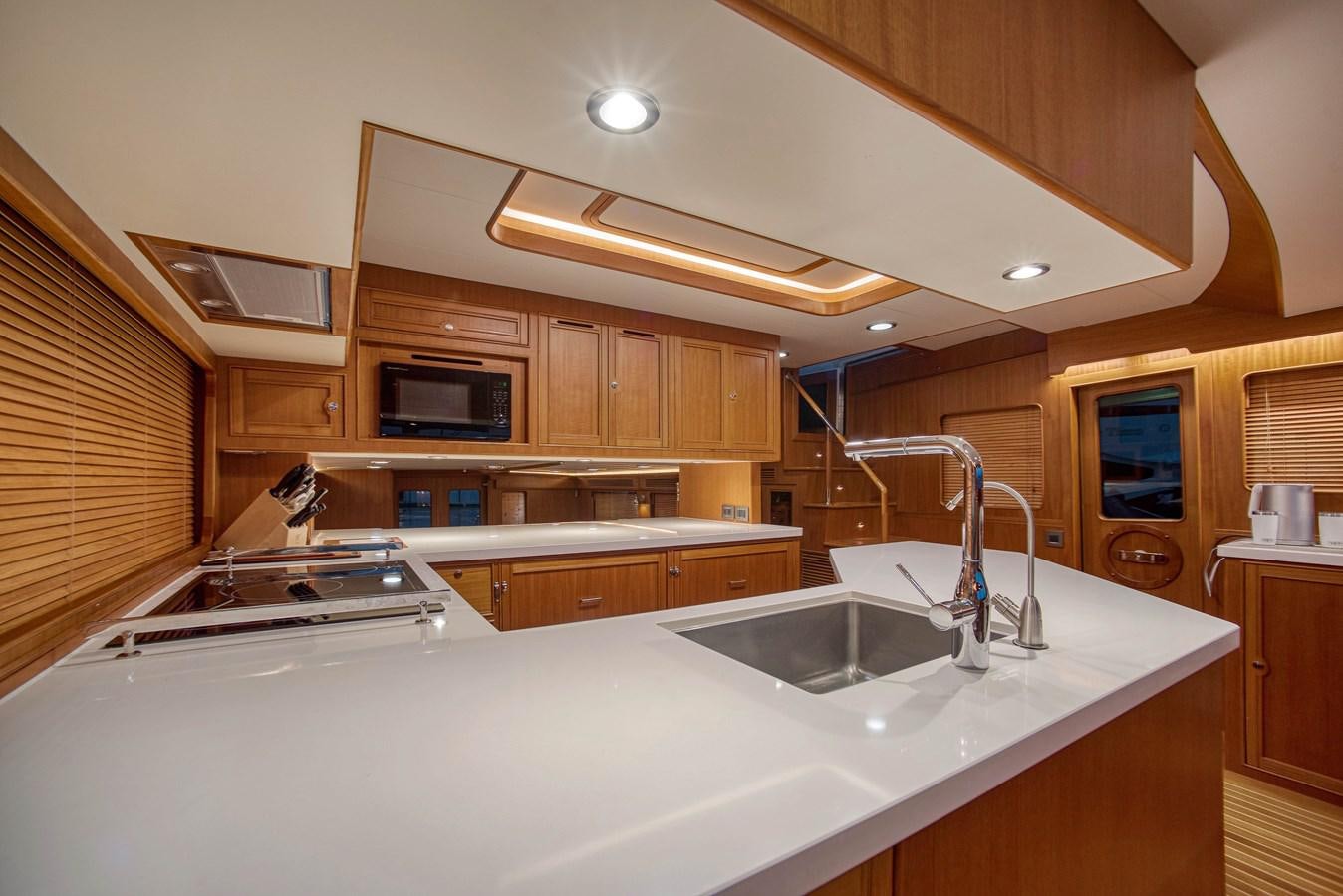 a kitchen with wooden cabinets aboard QUIXOTIC Yacht for Sale
