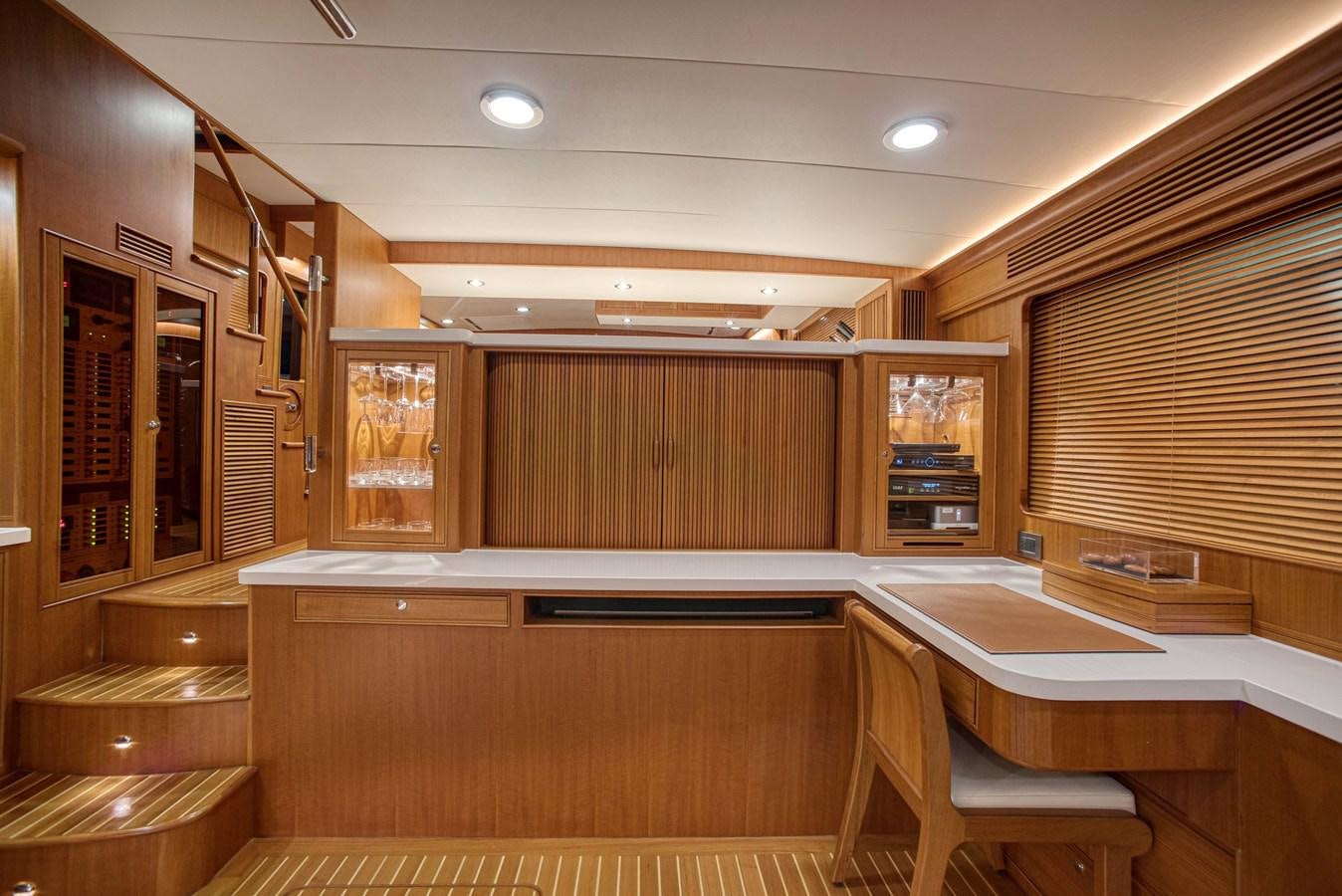 a room with wooden cabinets and a table and chairs aboard QUIXOTIC Yacht for Sale