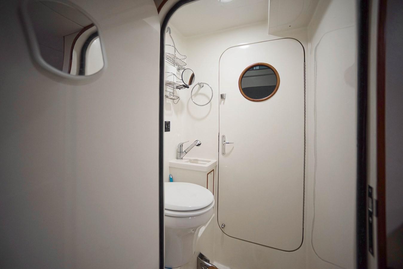 a bathroom with a toilet and a mirror aboard QUIXOTIC Yacht for Sale
