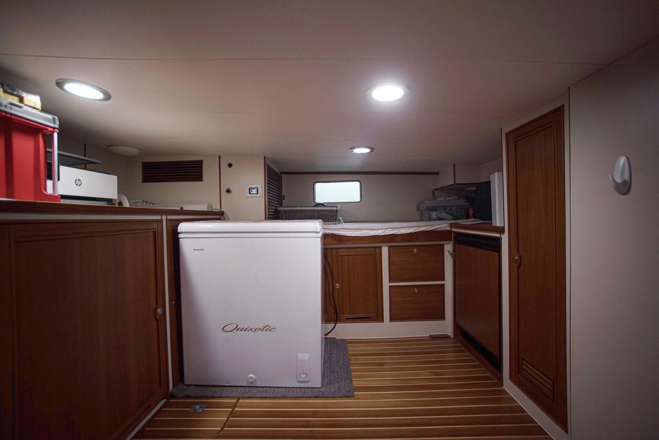 a room with cabinets and a refrigerator aboard QUIXOTIC Yacht for Sale