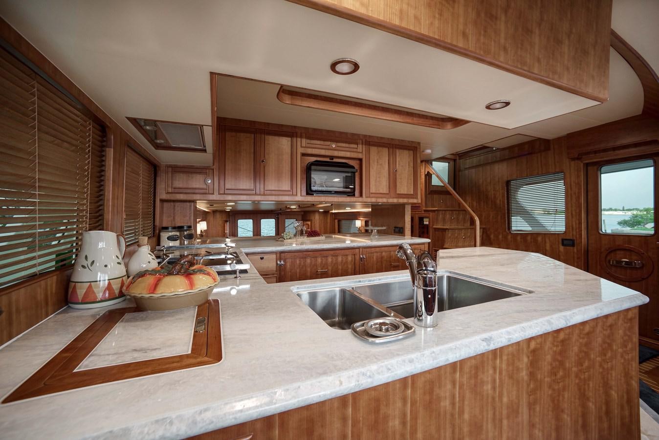 a kitchen with wooden cabinets aboard MAGIC Yacht for Sale
