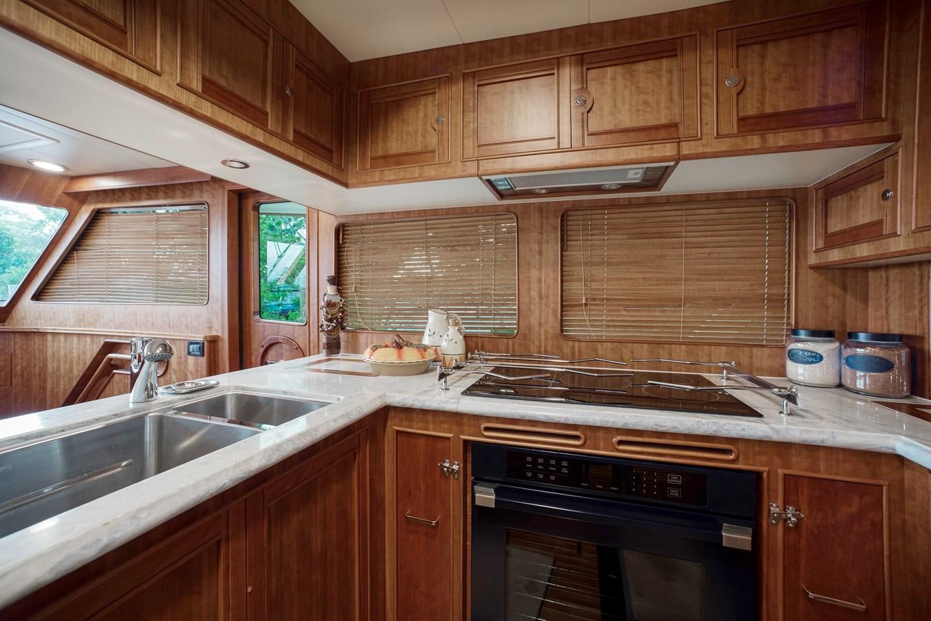 a kitchen with wooden cabinets aboard MAGIC Yacht for Sale