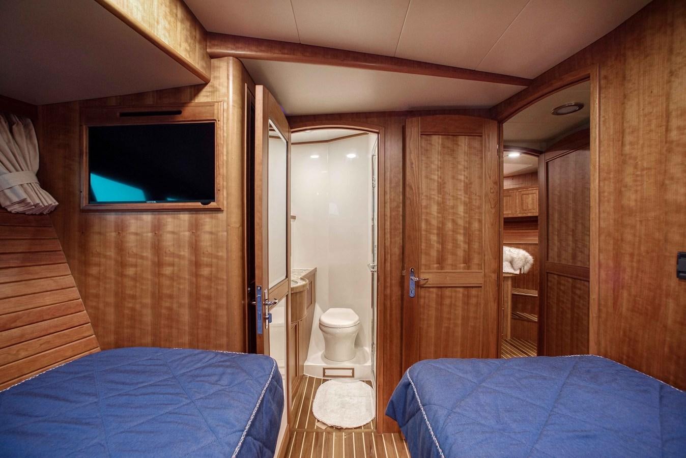 a room with a bed and a television aboard MAGIC Yacht for Sale