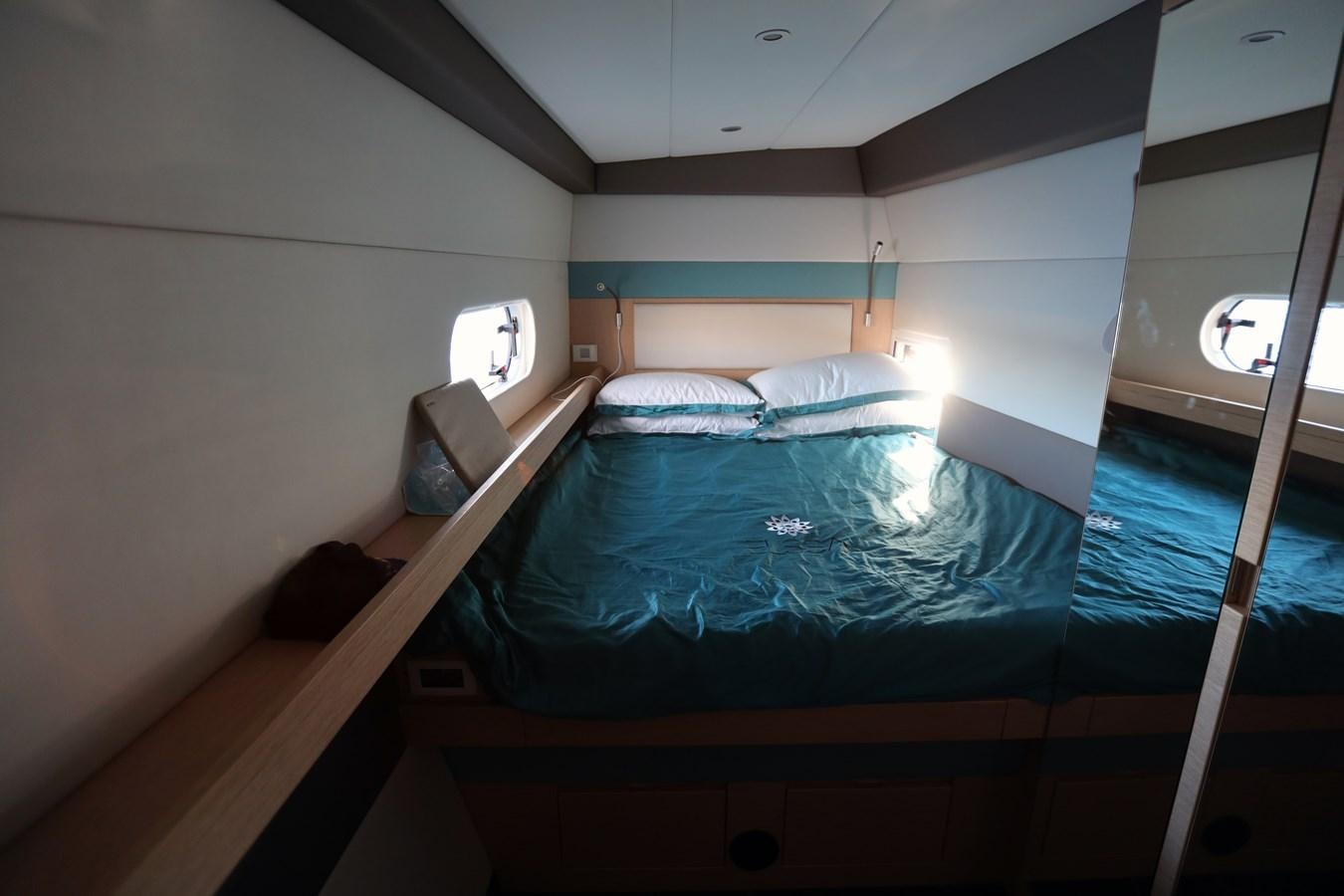 a bed with a blue comforter aboard ELSSA Yacht for Sale