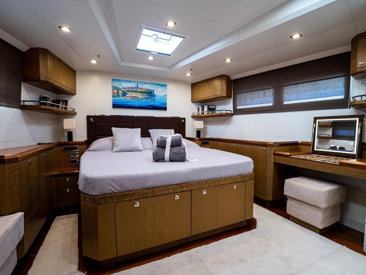 a bedroom with a bed and desk aboard BELKARA Yacht for Sale